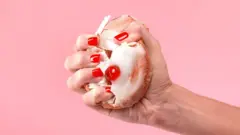Mano de mujer apretando con fuerza un bizcocho