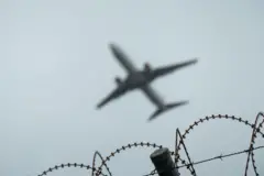 Avión sobre una valla de seguridad. 