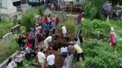 उत्तरी सुमात्रा में मर चुके लोगों की अस्थियों को कब्र से निकालते हैं लोग