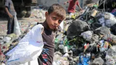 Un garçon palestinien cherche des objets recyclables dans une décharge à Deir el-Balah, le 13 juin 2024.