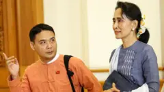 National League for Democracy party (NLD) leader Aung San Suu Kyi and Member of Parliament Thaw leave after attending a lower house of parliament meeting at Naypyitaw