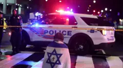 Um homem, com uma bandeira israelense com uma cruz no centro, ajoelha-se no cordão policial perto de onde dois funcionários da embaixada israelense foram mortos em Washington DC