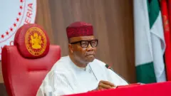 Nigeria senate president Godswill Akpabio wear white Agbada, microphone dey im front.