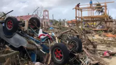 Upturned car and destroyed buildings