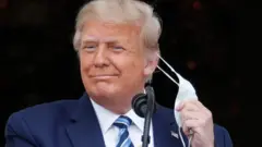 U.S. President Donald Trump takes off his face mask as he comes out on a White House balcony to speak to supporters gathered on the South Lawn for a campaign rally that the White House is calling a "peaceful protest" in Washington, U.S., October 10, 2020.