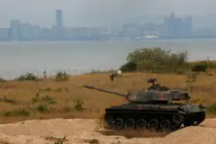 Um tanque de guerra próximo ao mar, com vista da China do outro lado