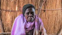 Umukecuru uri mu nkambi y'abavuye mu byabo bahungiye ahandi imbere muri Sudani 