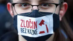 devojka nosi masku preko usta a preko maske je napisano "zločin bez kazne"
