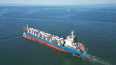 یک کشتی حامل کامیون چین را ترک می کند