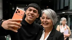La candidata comunista Jeannette Jara posa junto a un adherente durante la campaña presidencial de Chile.