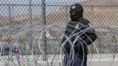 ਅਮਰੀਕੀ ਸਰਹੱਦ ਤੇ ਖੜ੍ਹਾ ਇੱਕ ਪੁਲਿਸ ਅਫ਼ਸਰ