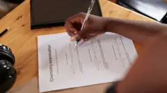 Foto of hand wey dey write exam