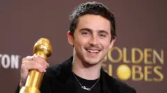 Timothée Chalamet brandissant son Golden Globe et souriant
