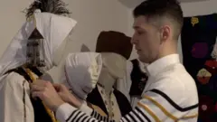 Milan sa lutkom obučenom u nošnju