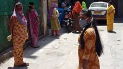 যৌনকর্মীরা অপেক্ষা করছেন কখন কোনও স্বেচ্ছাসেবী সংগঠন তাদের খাবার বিলি করতে আসবে।