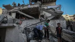 Gazatíes entre escombros en la ciudad de Gaza