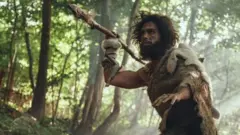 பழங்கால மனிதர் வேட்டையாடுவது போன்ற மாதிரிப் படம்