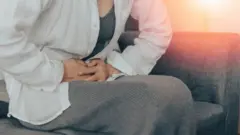 Mulher pressiona barriga