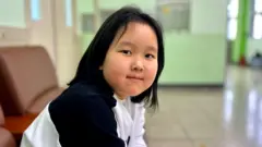 Kim Yana, seorang Koryoin dari Uzbekistan, melihat ke arah kamera.