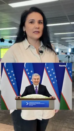 Азиза Қадам, олд қисмда эса Ўзбекистон президенти Шавкат Мирзоёев Тадбиркорлар билан очиқ мулоқот тадбирида минбарда нутқ сўзлаяпти 