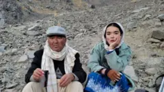 شمامه و پدرش در دامه یک کوه نشسته است 