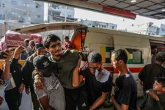 Jovem ferido sendo levado por pessoas