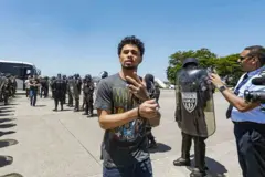 Um venezuelano detido gesticula enquanto caminha para embarcar em um voo para a Venezuela como parte de um acordo de troca de detentos entre a Venezuela e os Estados Unidos.