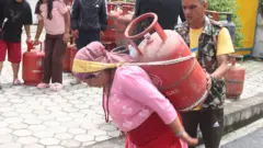 पिट्ठ्यूँमा ग्यास बोक्दै एक महिला