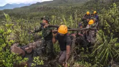 Tim SAR gabungan membawa kantong berisi jenazah pendaki korban erupsi Gunung Dukono di Kecamatan Galela, Kabupaten Halmahera Utara, Maluku Utara, Sabtu (09/05).