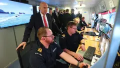 လူမဲ့ ရေအောက်ဒရုန်းတွေကို အဝေးက ထိန်းချုပ်နေတာကို ဗြိတိန် ကာကွယ်ရေး ဝန်ကြီး ကြည့်ရှုနေစဥ်