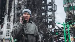 A resident in front of a building shelled by the Russian army in Borodyanka