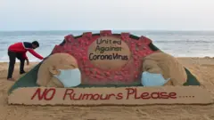 L'artiste indien Sudarsan Pattnaik met la touche finale à une sculpture de sable sur la plage de Puri
