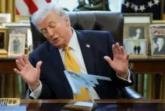 ينظر ترامب إلى نموذج طائرة تذكاري لعملية "مطرقة منتصف الليل" في 16 مارس/آذار 2026. 