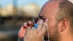 شخص يرتدي كمامة