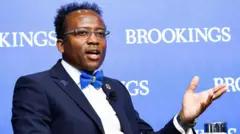 Foto de Landry Signé conversando e gesticulando.