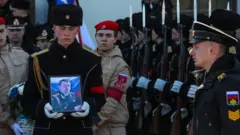 Ölen askerin fotoğrafı törende taşınırken