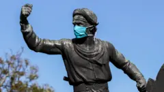 Estatua de gaucho en Montevideo con mascarilla.