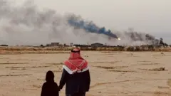 والد فاطمة وشقيقتها يشاهدان الدخان السام المنبعث من التوهجات بالقرب من منزلهما.
