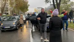 Ljudi na putu i automobili