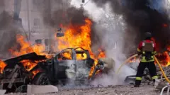 Firefighters extinguish fires in cars fires following a Russian missile attack on Sumy, Ukraine on April 13, 2025. 