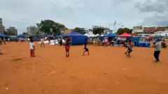 Crianças brincam no estádio de Playa Grande, que hoje abriga um dos refúgios para desabrigados