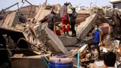 Equipes de resgate trabalham no local de um prédio que desabou após um forte terremoto em Mandalay, Mianmar.