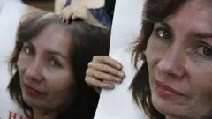 Руки с портретом Натальи Эстемировой