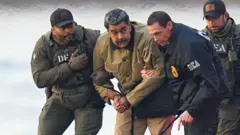 Nicolás Maduro é visto algemado após pousar em um heliporto em Manhattan, escoltado por agentes federais fortemente armados enquanto se dirige a um carro blindado rumo a um tribunal federal em Manhattan, em 5 de janeiro de 2026, na cidade de Nova York.