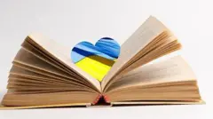 Колаж - відкрита книга, між сторінками намальоване блакитно-жовте серце.