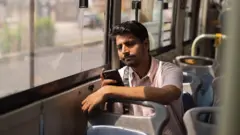 Young man using mobile phone while travelling in the bus