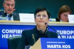 Žena, kratko ošišana sa naočarama, sedi za mikrofonom i odgovara na pitanja