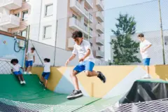 Crianças uniformizadas brincando em pista de skate