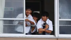 Os alunos assistem a prática de rugby da sala de aula em Ichihara