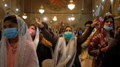 سيدات يصلين في صمت أثناء القداس في كنيسة القديس أندرو في كراتشي في باكستان